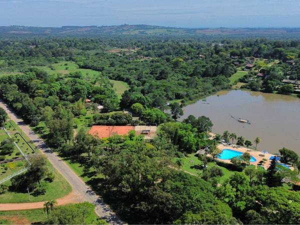 Vista aérea do Guaíba Country Club, com piscinas, quadras e o lago ao fundo