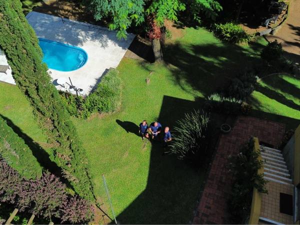 Piscina do Guaíba Country Club vista de cima, cercada de gramado e árvores