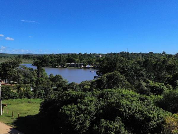 Lago cercado de mata em dia de céu azul, no Parque Eldorado